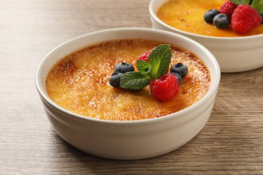 Tahta masada taze böğürtlenli leziz creme brulee.