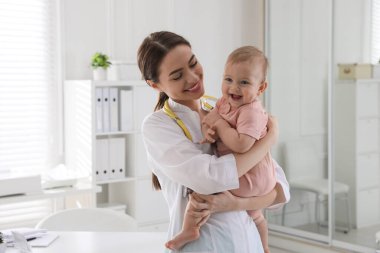 Klinikte küçük şirin bir bebeği olan genç bir çocuk doktoru.