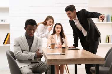 Afrika kökenli Amerikalı iş arkadaşına bağıran bir adam. Irkçılık kavramı