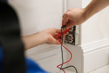 Elektrikçi ve testçi içeride voltajı kontrol ediyor, yakın plan.