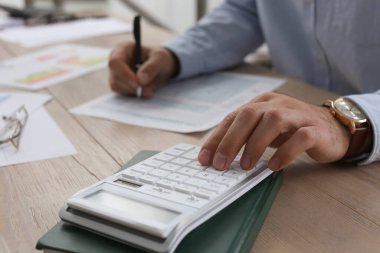 Ahşap masada çalışan vergi muhasebecisi, yakın plan.