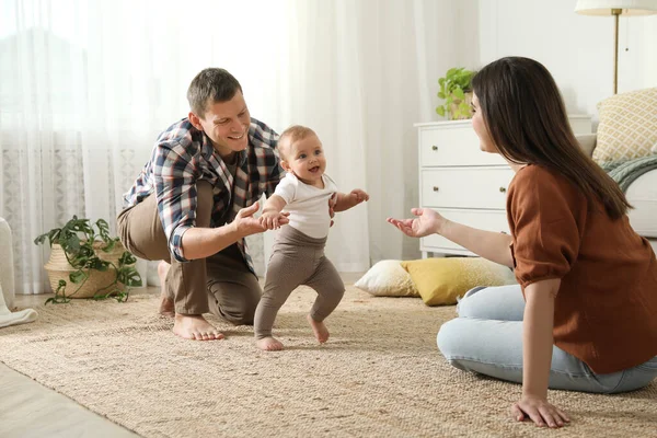 Padres Apoyando Hija Mientras Ella Aprende Caminar Casa —  Fotos de Stock