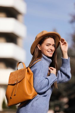 Sonbahar günü şık bir sırt çantası olan genç bir kadın.