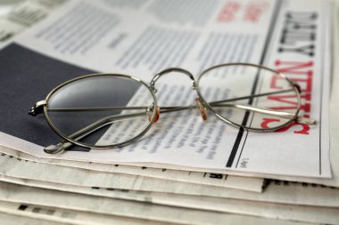 Gözlükler gazete yığınında, yakın çekim görüntüsü