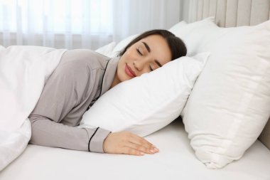 Evdeki yatakta uyuyan güzel bir genç kadın.