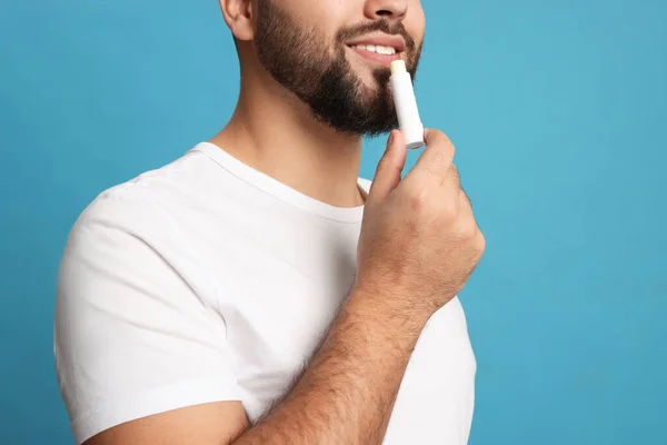 Jovem Aplicando Bálsamo Labial Fundo Turquesa Close — Fotografia de Stock