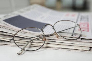 Gazeteler ve bardaklar beyaz masada, yakın plan.