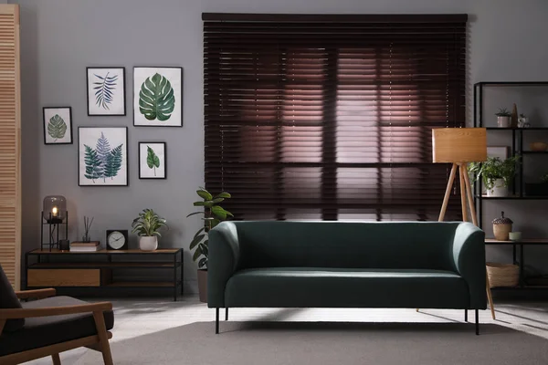 快適なソファと緑の観葉植物とスタイリッシュなリビングルームのインテリア — ストック写真