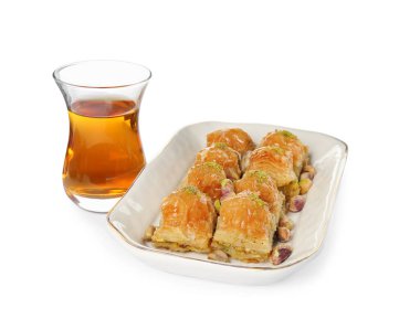 Fıstıklı enfes baklava ve beyaz arka planda sıcak çay.