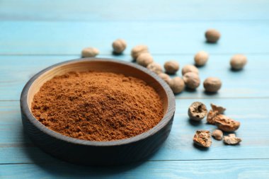 Bir kase hindistan cevizi tozu ve tohumlar açık mavi ahşap masada.