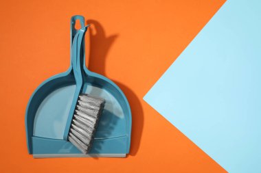Renkli arka planda plastik süpürge ve faraş, üst manzara. Metin için boşluk