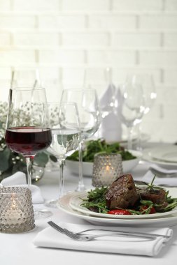 Restoranda servis edilen lezzetli ızgara et, sebze ve şarap.