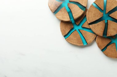 Beyaz mermer masada, düz yerde duran ahşap bardak altlıkları. Metin için boşluk