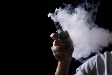 Siyah arka planda elektronik sigara kullanan adam, yakın plan. Metin için boşluk