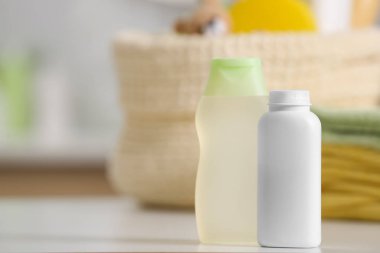 Beyaz masa üzerinde bebek kozmetik ürünleri ve havlular, metin için yer