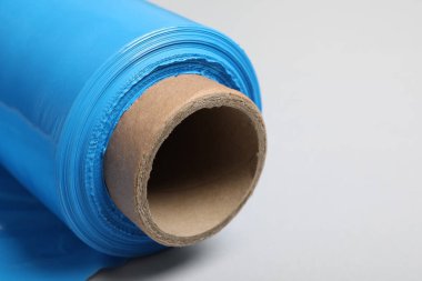 Beyaz arka planda plastik streç film rulosu, yakın plan. Metin için boşluk