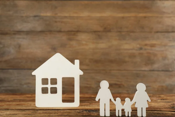 木製のテーブルの上の家族の図と家のモデル 養子縁組の概念 — ストック写真