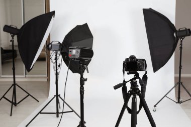 Fotoğraf stüdyosunda kamera ve profesyonel ışıklandırma ekipmanı olan tripod.