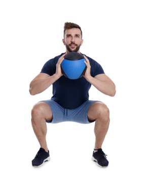 Atletik adam beyaza izole edilmiş ilaç topuyla çömelme yapıyor.