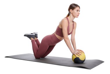 Spor yapan atletik bir kadın, beyaza izole edilmiş ilaç topuyla egzersiz yapıyor.