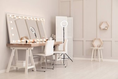 Modern mirror with light bulbs on dressing table in makeup room clipart