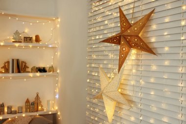 Güzel dekoratif yıldızlar ve odadaki şenlikli ışıklar. Noel atmosferi