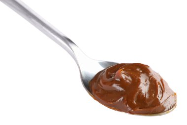 Beyaz üzerine izole edilmiş kaynamış konsantre sütle dolu kaşık.