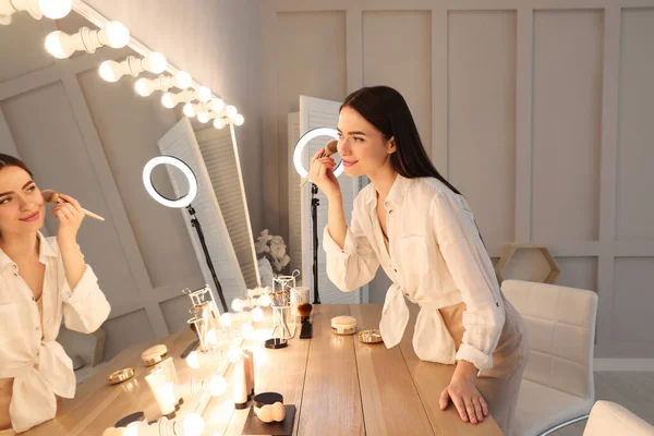 Jeune Femme Appliquant Maquillage Près Miroir Éclairé Intérieur — Photo