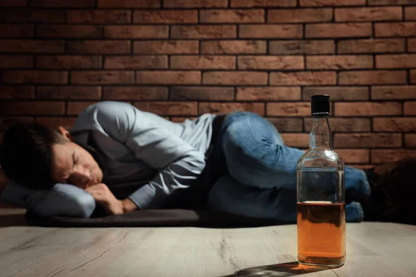 Kırmızı Tuğla Duvarın Yanında Yatan Bağımlı Adam Alkol Şişesine Odaklan — Stok fotoğraf