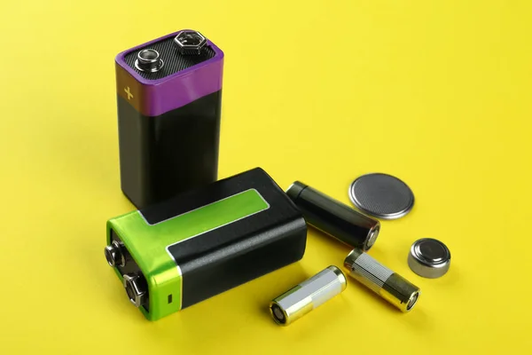 Verschiedene Arten Von Batterien Auf Gelbem Hintergrund — Stockfoto
