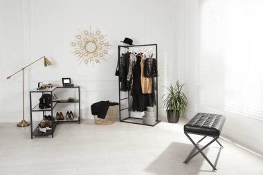 Moda kıyafetler, ayakkabılar ve aksesuarlarla dolu şık bir soyunma odası.