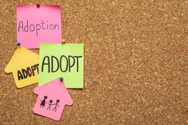 Bir sürü renkli nota mantar panoya tutturulmuş, yazı için boşluk. Çocuk evlat edinme kavramı