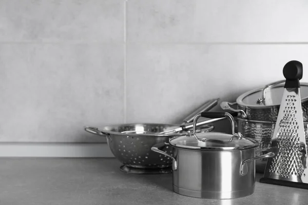 台所の灰色のカウンターの上に異なる調理器具のセット テキストのスペース — ストック写真