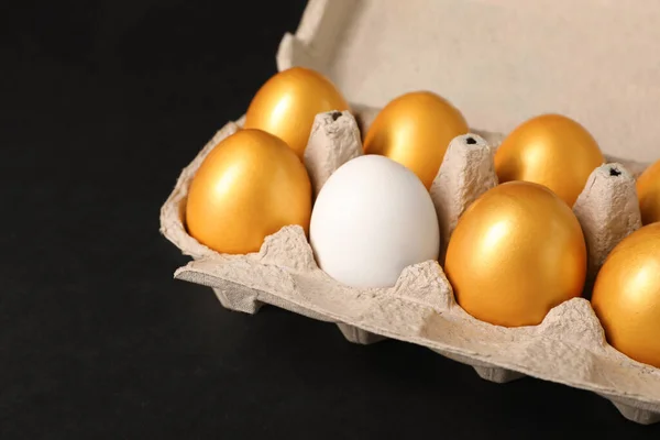 Συνηθισμένο Αυγό Κοτόπουλου Μεταξύ Των Χρυσών Κουτί Μαύρο Φόντο Closeup — Φωτογραφία Αρχείου
