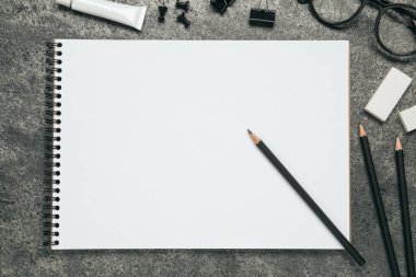 Düz kompozisyon ve gri taş masanın üzerinde boş çizim defteri vardı. Metin için boşluk