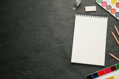 Siyah tahta üzerinde boş çizim defteri ile düz kompozisyon yatıyordu. Metin için boşluk