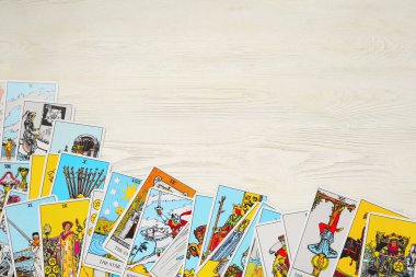 Tarot cards on white wooden table, top view. Space for text clipart