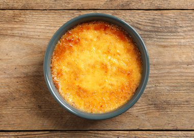 Ahşap masada seramik çerçeveli nefis krema brulee, üst manzara.