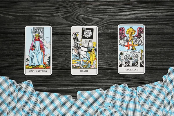 Tarot cards on black wooden table, flat lay