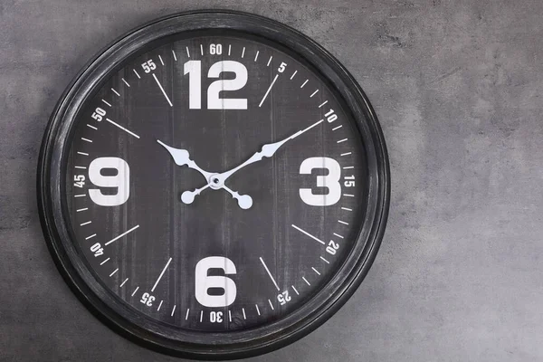 灰色の壁に掛けられたスタイリッシュなアナログ時計 — ストック写真