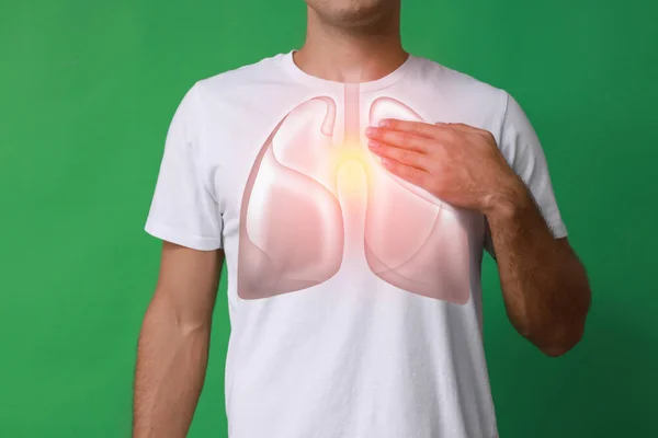 緑の背景に肺のイラストと胸の近くに手を保持男 クローズアップ — ストック写真