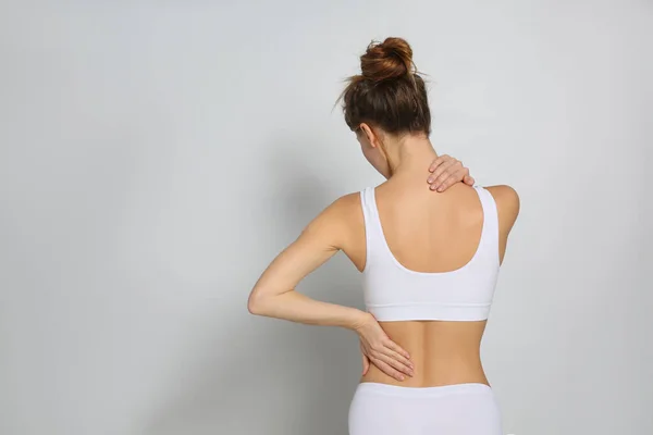 Mujer Que Sufre Dolor Espalda Sobre Fondo Gris Claro Espacio —  Fotos de Stock