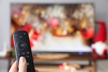 Uzaktan kumandalı bir kadın evde televizyon seyrediyor, kapatıyor. Metin için boşluk