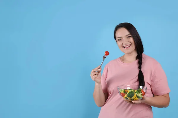 美しい太りすぎの女性は テキストのためのスペース 薄い青の背景にサラダを食べる 健康的な食事 — ストック写真