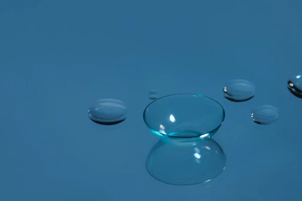 Lente Contato Gotas Água Superfície Refletora Azul Espaço Para Texto — Fotografia de Stock