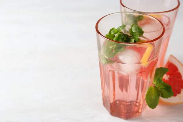 Deliciosos Cócteles Con Pomelo Menta Bolas Hielo Mesa Blanca Espacio —  Fotos de Stock