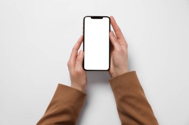 Beyaz arka planda akıllı telefonu olan kadın, üst görünüm