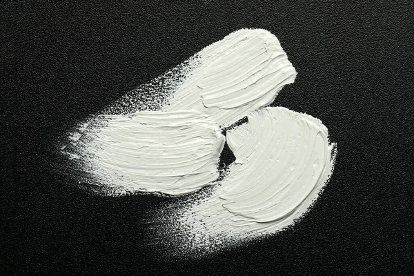 黒いキャンバスに白い油絵具のストローク トップビュー — ストック写真