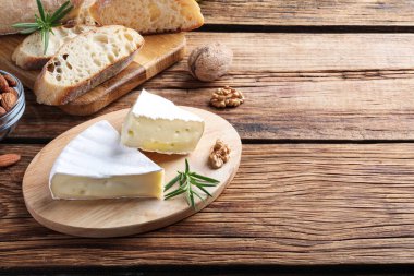 Lezzetli biberiyeli Brie peyniri, ahşap masada ekmek ve fındık, metin için yer