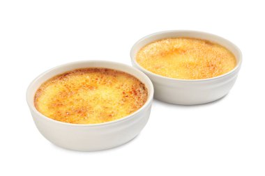 Beyaz arka planda seramik rameklerin içindeki lezzetli creme brulee